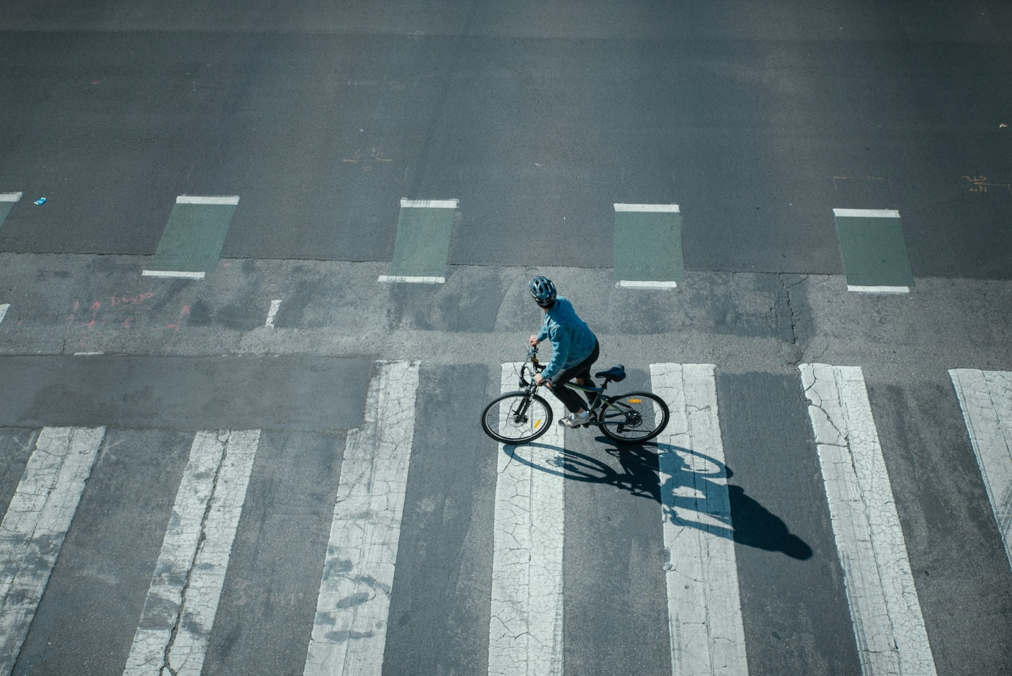 A person riding an e-bike on an asphalt road
