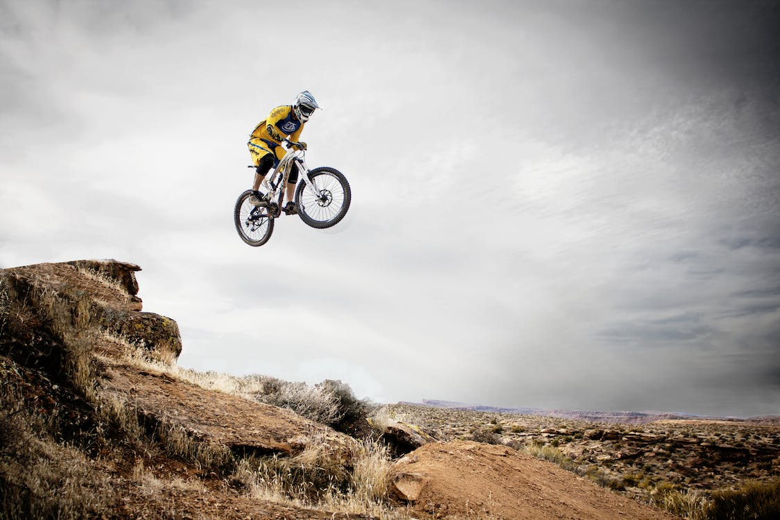 An electric bike rider jumping across a hill
